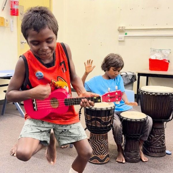Pularumpi students playing ukulele and djembe drums